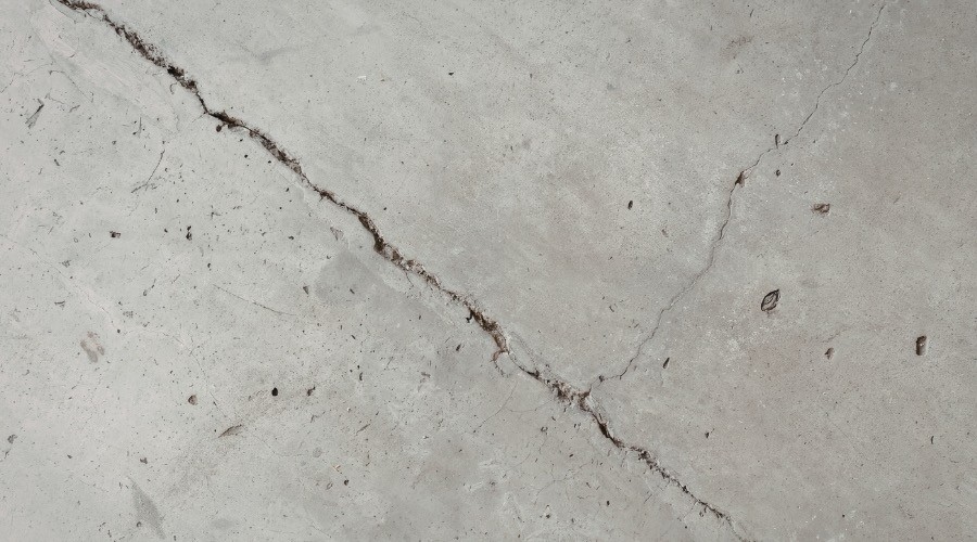 Cracked concrete foundation illustrating signs of a slab leak.